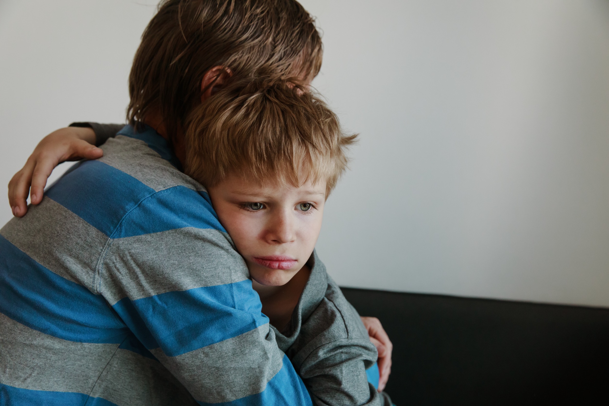 Parent comforts sad child.